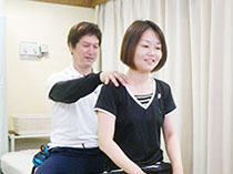 和やかに肩の施術を受ける女性
